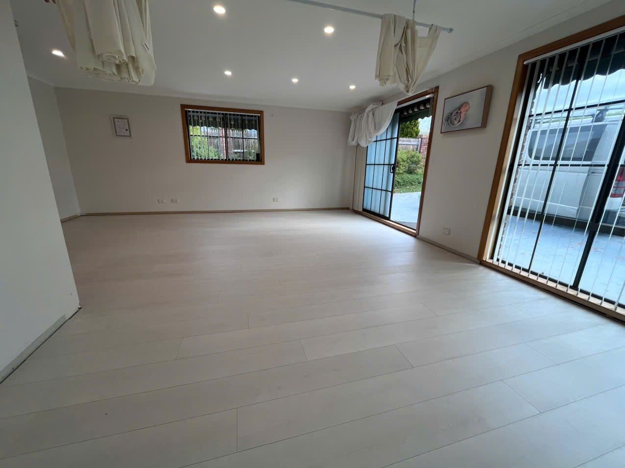 Whitewashed oak-look boards lightening a room framed by timber security doors.