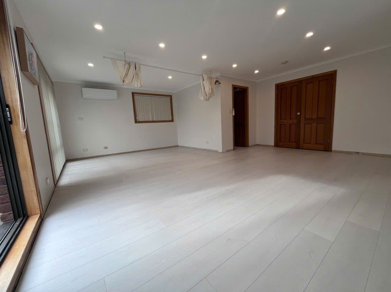 The pale boards wall to wall, cedar double doors kept as the feature.